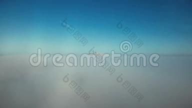 在晴朗的蓝天中，无人驾驶飞机在白云之上飞向空灵的圣米歇尔山金堡尖塔。